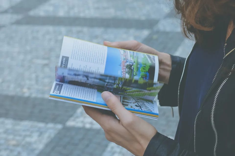 Persona che sfoglia una brochure illustrata, esempio di stampa coordinata LimCrea