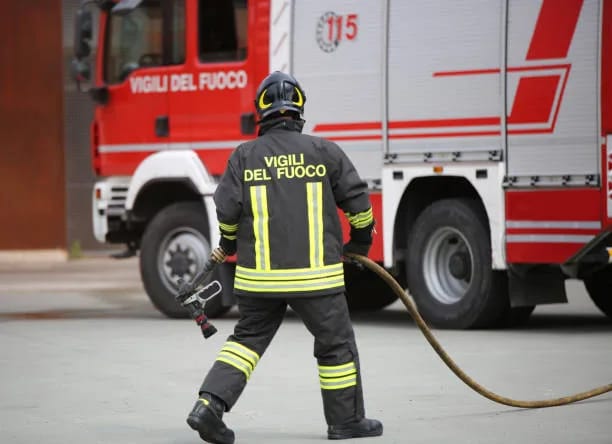 Vigile del fuoco al lavoro davanti a un’autopompa